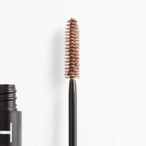 Eine Mascara-Bürste mit braunen Borsten und schwarzem Griff, neben einem schwarzen Behälter.