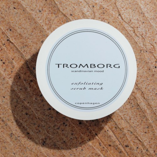 Ein weißer Behälter mit exfolierendem Peelingmask auf brauner Textur, beschriftet mit 'TROMBORG' und 'scandinavian mood' sowie 'copenhagen'.