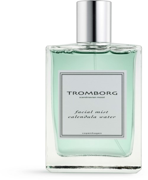 Eine klare Glaspflasche mit grüner Flüssigkeit und silberner Kappe. Das Etikett liest 'TROMBORG facial mist calenula water'.