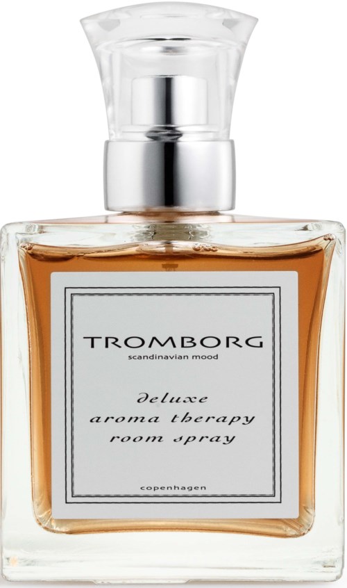 A glass bottle of perfume with a silver cap and a white label, labeled Tromborg deluxe aroma therapy room spray.