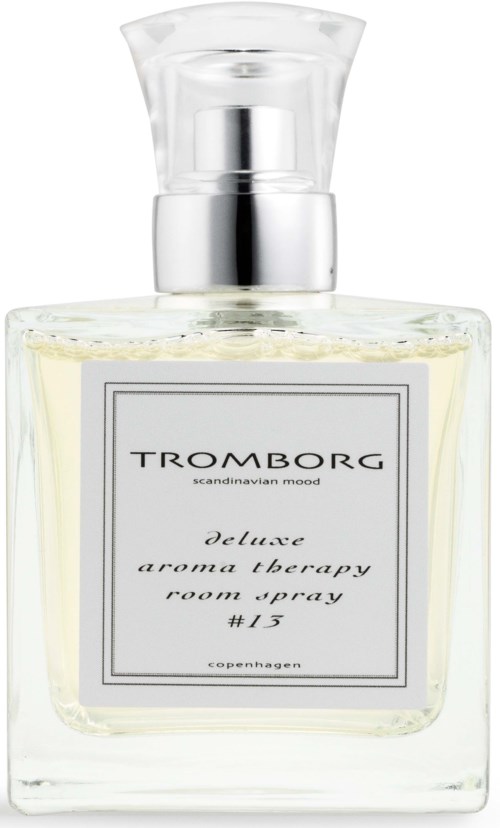 En tydlig parfymflaska i glas med silverlock och vit vätska. Etiketten säger Tromborg deluxe aroma therapy.