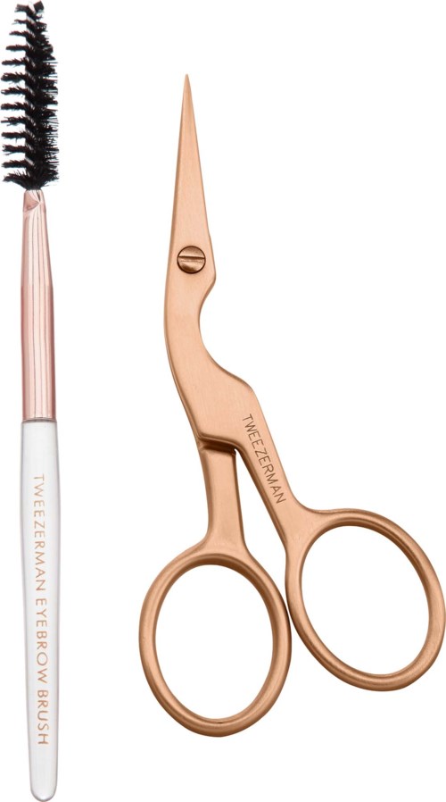 Eyebrow scissors and brush with a pink handle and gold blades and rings.