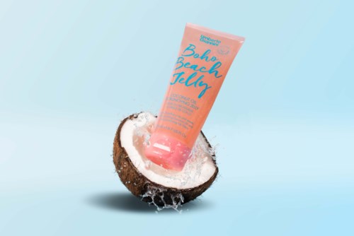 Eine Tube mit der Aufschrift 'Bahr Beach Jelly' befindet sich in einer halbierten Kokosnuss vor blauem Hintergrund.