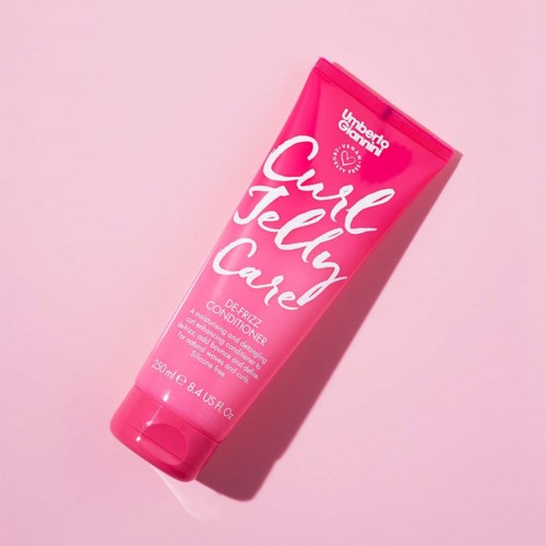 Ein hellrosa Tube mit Curl Jelly Cave Conditioner auf rosa Hintergrund.