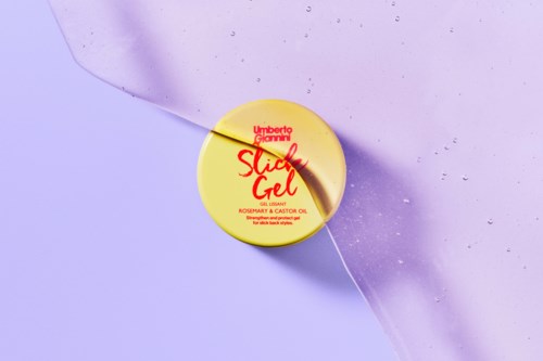 Round yellow container with red and black text, on a lavender background with water droplets and a torn paper edge.