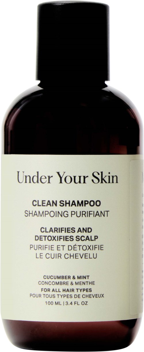 Donkere fles met label 'Under Your Skin' voor komkommer en munt shampoo.