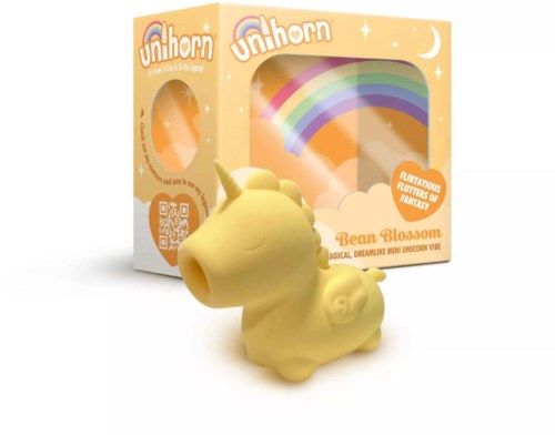 A yellow unicorn figurine with a rainbow and moon background, in front of a box labeled "Bean Blossom."