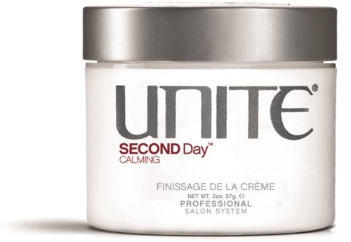 Ein weißer Behälter mit silbernem Deckel mit der Aufschrift "UNITE SECOND Day CALMING" Haarcreme.