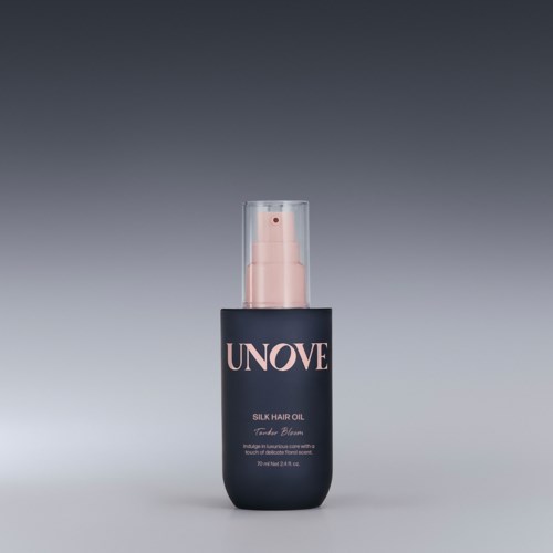 Een zwarte fles met 'UNOVE Silk Hair Oil' label, roze pomp en doorzichtige dop.