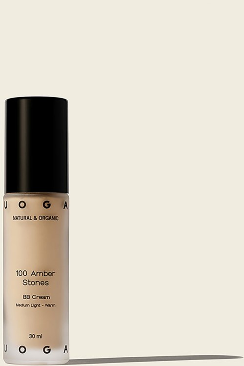 Eine Flasche Foundation mit schwarzen Deckel, beige Flüssigkeit, beschriftet 'UOGA' und 'Amber Stones'.
