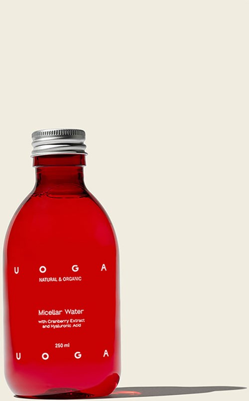 Eine rote Flasche mit "Micellar Water" und Metallkappe vor weißem Hintergrund.