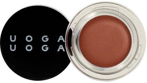 Ein kleiner Behälter mit brauner Lippenstift neben einem schwarzen runden Logo mit weißem Text "UOGA UOGA."