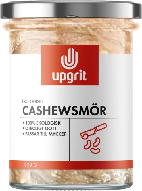 A jar of organic cashew butter with a silver lid, red and white label showing brand Upgrit and product details.