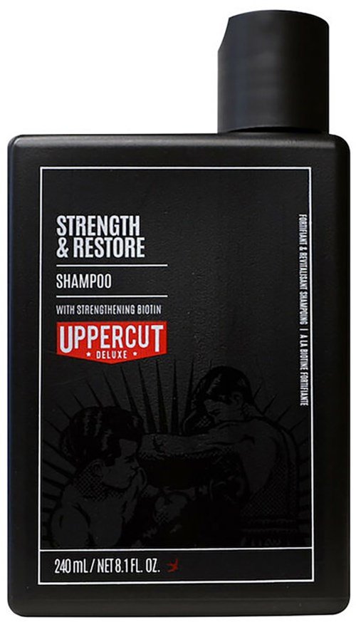 A black shampoo bottle labeled 'Strength & Restore' with 'Uppercut Deluxe' logo, featuring a boxing scene illustration.
