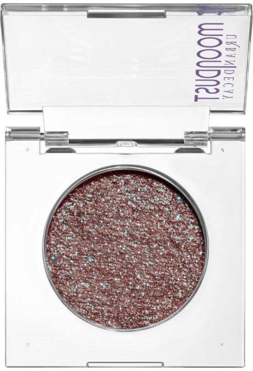 A round eyeshadow with glittery, pinkish hue in a clear compact. The brand name is partially visible on the lid.