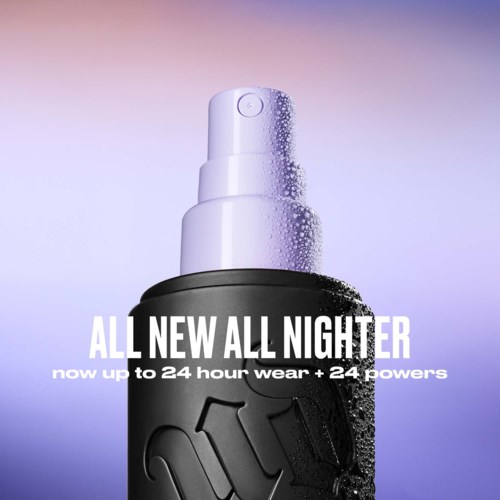 A black spray bottle advertised for all-night wear and 24-hour power, with water droplets on it and purple background.