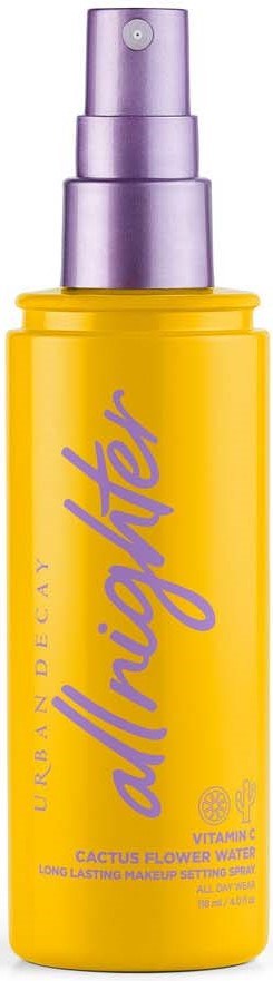 Gele fles met paarse spraydop, gelabeld 'all nighter' en 'Urban Decay'.