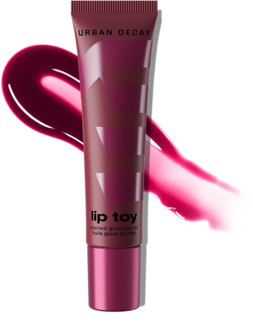 Urban Decay lip gloss i rör märkt lip toy med en rosa nyans, med en drag av glansigt rosa bakom.