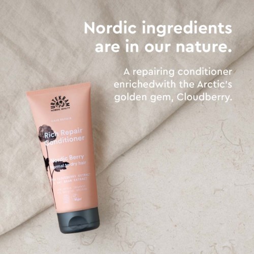 Roze tube conditioner met bessen op stoffen achtergrond, promoot ingrediënten uit het noorden.