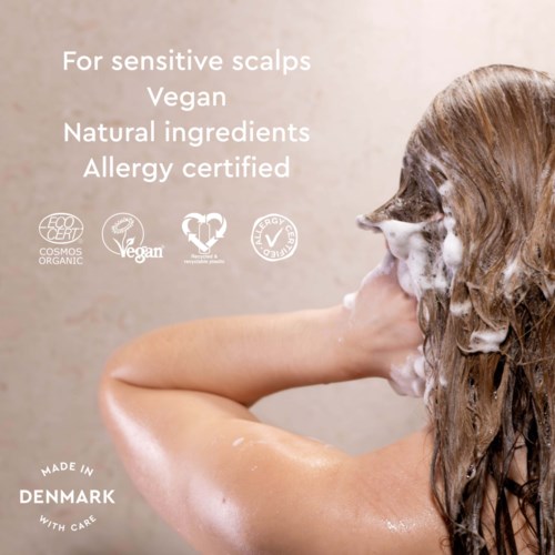 Produktetiketter visar naturliga ingredienser, vegansk, allergi-certifierad, tillverkad i Danmark, lämplig för känslig hårbotten.