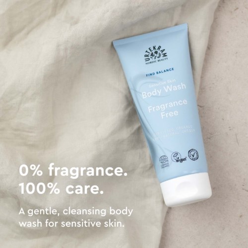 Eine hellblaue Tube mit Body Wash, Text über parfümfrei und sanfte Reinigung für empfindliche Haut. Liegt auf Stoff.