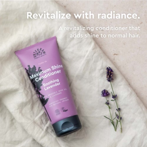 Een lavendelscentende haarconditioner genaamd 'Maximum Shine Conditioner' van Urtekram. Er liggen een paar lavendelstelen naast.