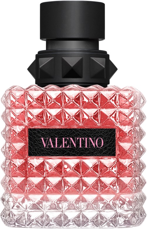 Een parfumfles met een getextureerde roze en witte ontwerpen, een zwarte dop en een zwart etiket met roze tekst.