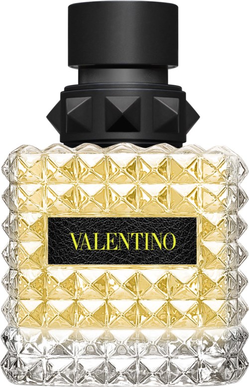 En flaska med ett texturerat glasmönster, svart lock och en gul etikett som säger 'VALENTINO'.