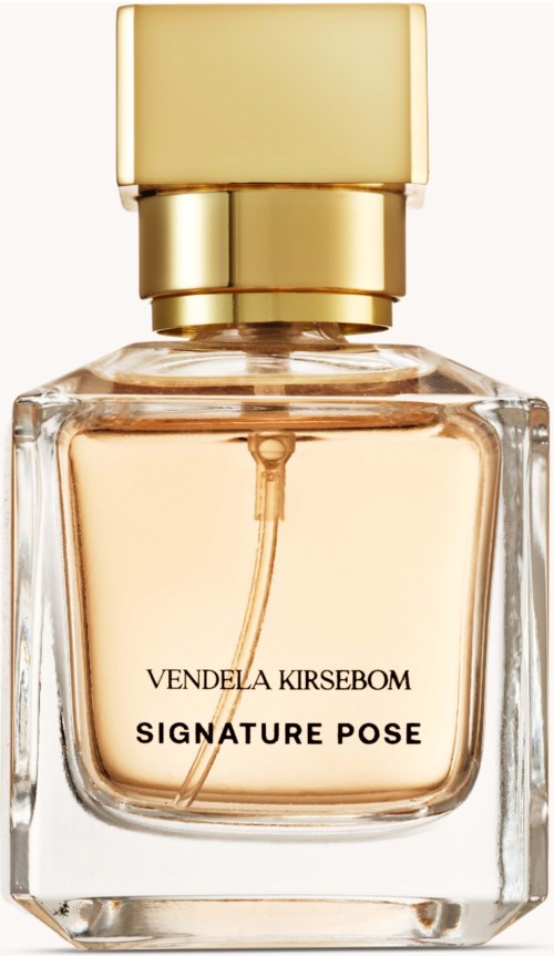 A perfume bottle with a gold cap and clear glass showing peach-colored perfume inside.