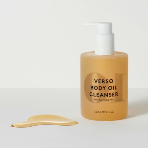 Een fles Verso body oil cleaner met uitgespoten vloeistof ernaast tegen een eenvoudige achtergrond.
