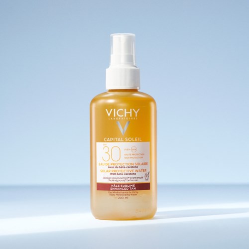 Eine goldene Sprayflasche Vichy Capital Soleil Sonnenschutz mit SPF 30, für verbessertes Bräunen und Wasserdichtigkeit.