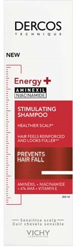 Eine Vichy Dercos Shampoo-Flasche mit roten und weißen Labels, die Energie, anregende Wirkung und Haarausfallprävention betonen.