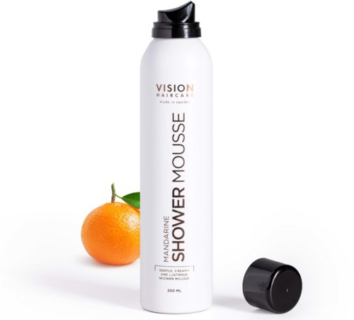 Valkoinen pullo, jossa musta korkki, etiketissä 'Mandarine Shower Mousse,' ja sen vieressä mandariini.