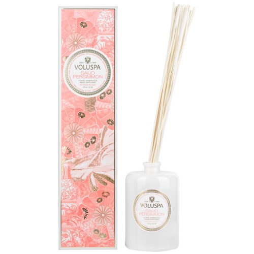 Eine Schachtel mit rosa Blumenmuster und eine weiße Flasche mit Stäbchen, wahrscheinlich für Duft oder Räucherstäbchen.