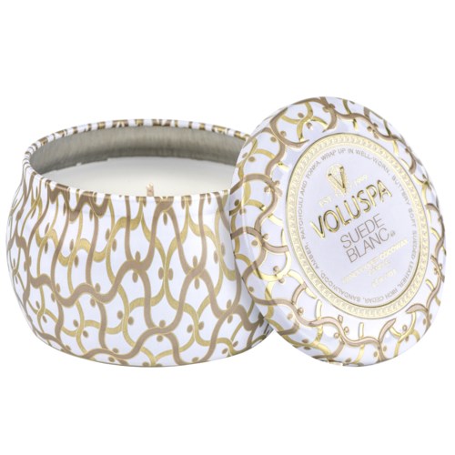 Pyöreä valkoinen ja kultainen säilytine, jossa lukee "Voluspa Suede Blanc". Se vaikuttaa tuoksukynttilältä tai kosmetiikkatuotteelta.