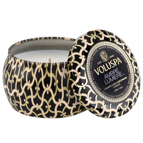 Dekorativer Kerze mit schwarz und gold Muster, beschriftet 'Voluspa Ambre Lumiere', in einer runden Dose.