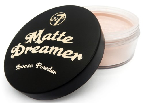 Pyöreä musta rasia, jonka kantta lukee 'Matte Dreamer' ja 'Loose Powder', ja se on osittain auki, paljastaen vaaleanpunertavaa jauhetta.