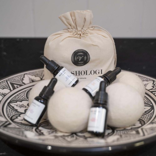 A cashmere bag surrounded by five small bottles on a decorative plate.