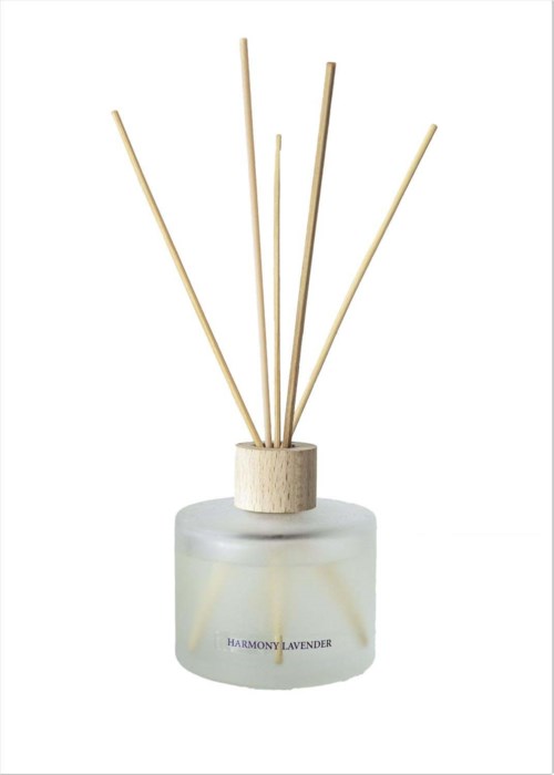 A round jar with a lavender scent label and reed sticks sticking out of it.