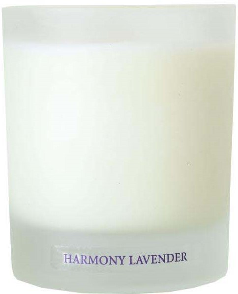 A white candle with a label that says "HARMONY LAVENDER."
