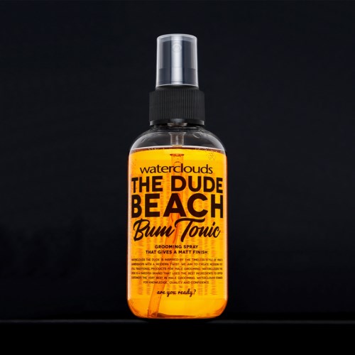 A spray bottle with orange label says 'The Dude Beach Bum Tonic' and 'grooming spray for a matte finish.'
