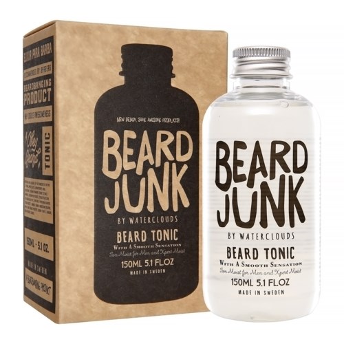 Eine klare Flasche und ein brauner Karton, beide mit "Beard Junk" Bart-Tonikum beschriftet, im Einzelhandel.