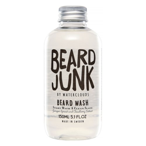 Eine klare Flasche mit silberner Kappe, beschriftet 'Beard Junk', enthält Bartwäsche mit natürlichen Zutaten.