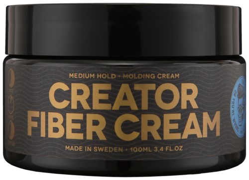 Ein schwarzer Behälter mit goldenen und blauen Etiketten, enthält Creator Fiber Cream für mittleren Halt, hergestellt in Schweden.