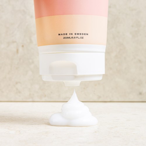 Een tube spuit witte crème op een lichte ondergrond, met labels die aangeven dat het in Zweden is gemaakt.