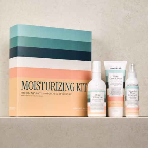 Een vochtinbepakkingsset voor droog haar met shampoo, conditioner en spray in pastelkleurige verpakkingen en een doos.