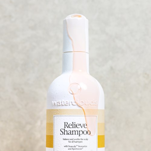 Eine weiße Flasche mit Pumpkopf, beschriftet 'Relieve Shampoo' für Kopfhaut und Haargesundheit.