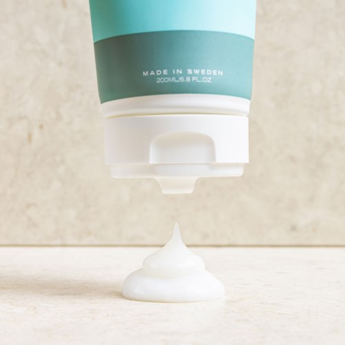 Ein Tube, die weißen Schaum oder Creme auf eine glatte Oberfläche abgibt.
