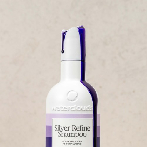 Eine weiße Shampooflasche mit lila Verschluss und Label, das 'Silver Refine Shampoo' sagt.