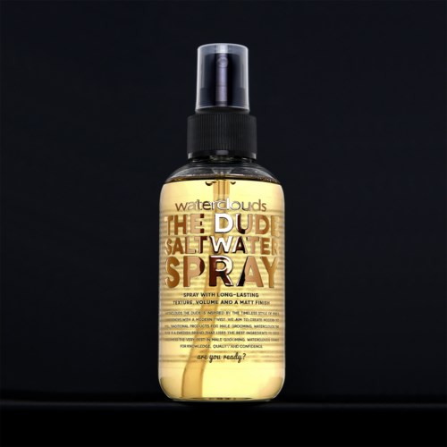 Sprühflasche mit Etikett "The Dude Salt Water Spray" für Haare, mit schwarzen Deckel und durchsichtigem Körper mit gelber Flüssigkeit.